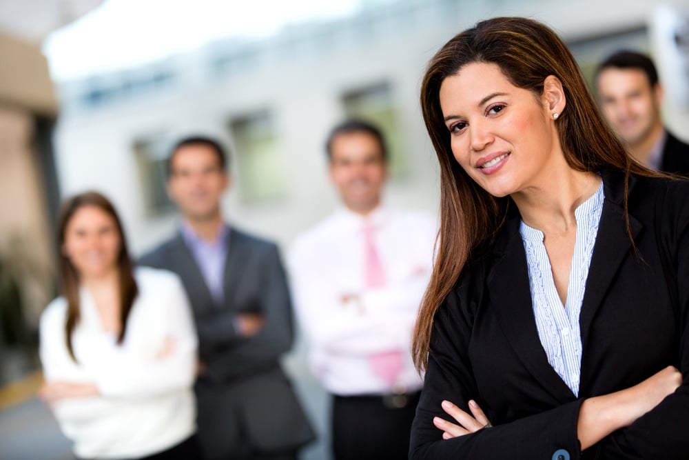 Female business leader with her team at the background