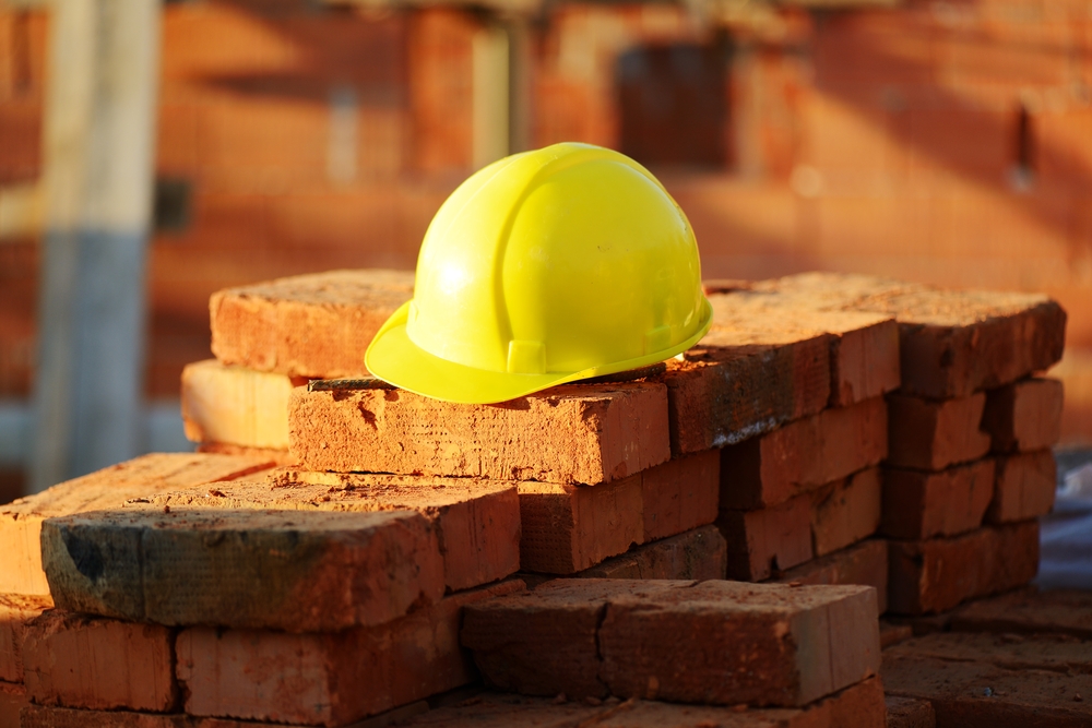 Under construction, helmet and bricks for building site